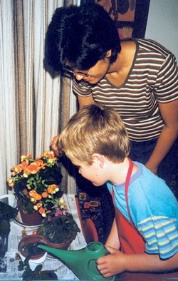 A young boy watering plants